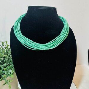 Multi-strand green seed bead necklace.